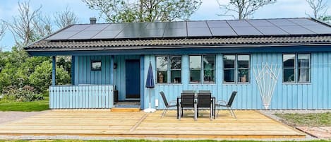 A blue building with a covered patio area, a door, and windows.