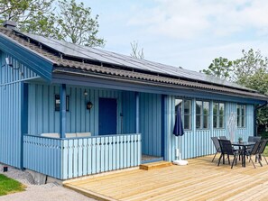 A blue building with a wooden deck and a covered outdoor seating area. - 6 Person Holiday Home in Kopingsvik (Kopingsvik)
