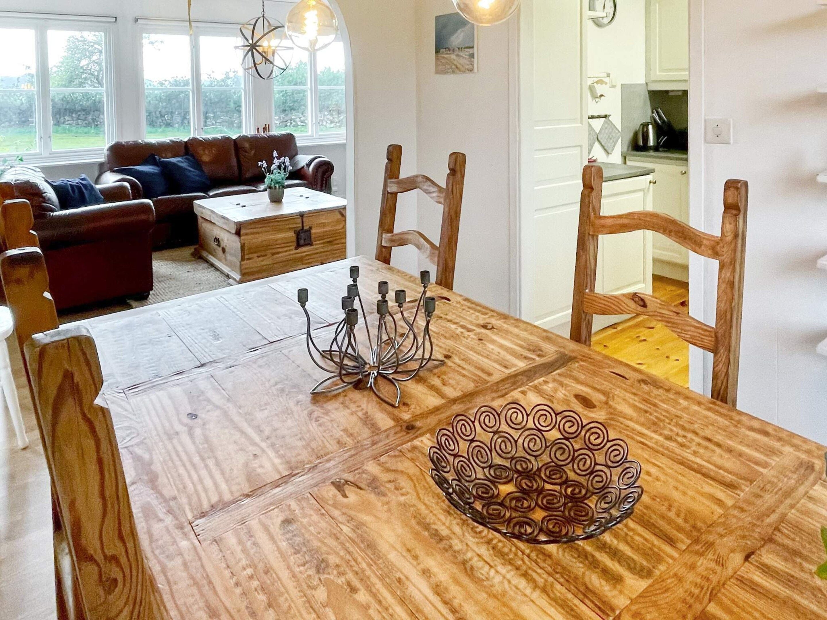 A dining area with a wooden table, chairs, a decorative glass bowl, and a candelabra.