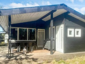 A modern house with a covered porch, large windows, and a small deck area.