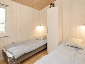 A room with two single beds, a wardrobe, and a window. - 8 Person Holiday Home in Albaek (Jerup)