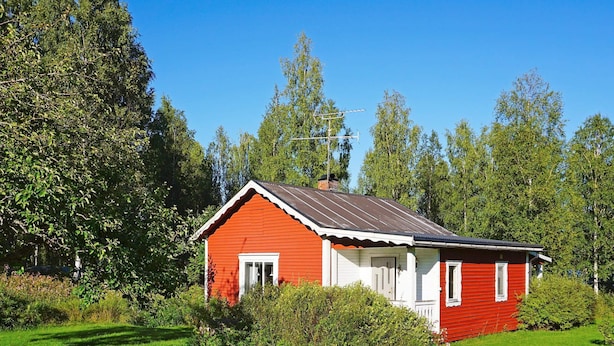 A red wooden house with a white door and windows, surrounded by green grass and trees. - 6 Person Holiday Home in Torsby (Torsby)