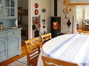 A cozy room with a fireplace, wooden furniture, and a dining area. - 6 Person Holiday Home in Ostmark (Östmark)