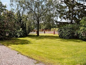 A well-maintained grassy area with a gravel path leading to a red and white fence. - 6 Person Holiday Home in Odensvi (Gamleby)
