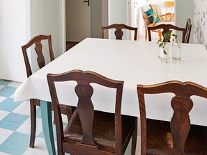 A dining table with a white tablecloth, surrounded by wooden chairs with curved backs. - 6 Person Holiday Home in Odensvi (Gamleby)