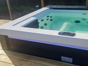 Un bain à remous doté d’un panneau de commande et d’une étiquette sur le côté.