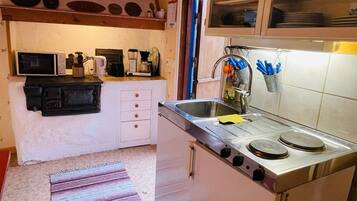 A compact kitchen with a stove, sink, and cabinets.