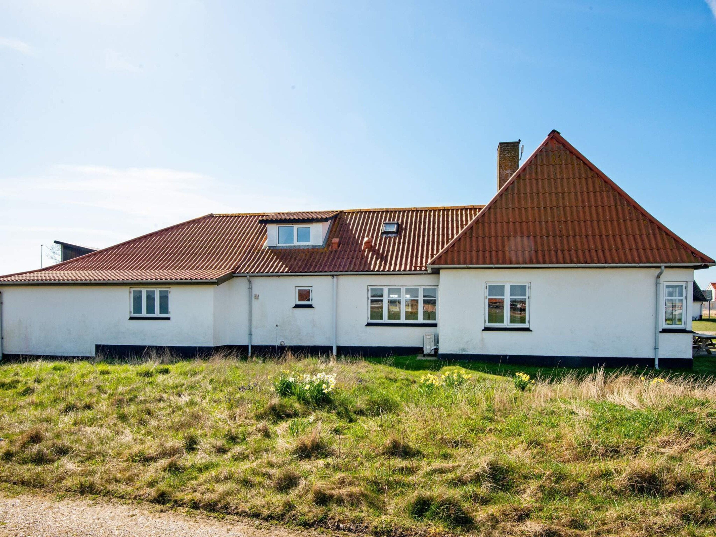 A single-story house with a sloped roof, a small attached garage, and a grassy yard.