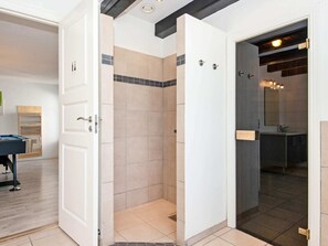 A modern bathroom with a walk-in shower, a sink, and a mirror.