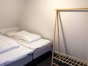 A single bed with a wooden frame and a mattress labeled 'DREAMY' in a room with white walls and a black floor. - 4 Star Holiday Home in Harboore (Harboore)