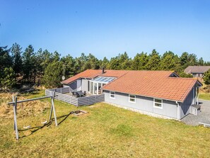 A modern house with a red-tiled roof, a covered patio, and a small deck. - 10 Person Holiday Home in Blavand (Blavand)