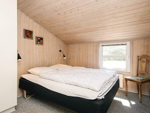 A bedroom with a bed, a window, and two wall-mounted lamps. - 10 Person Holiday Home in Blavand (Blavand)