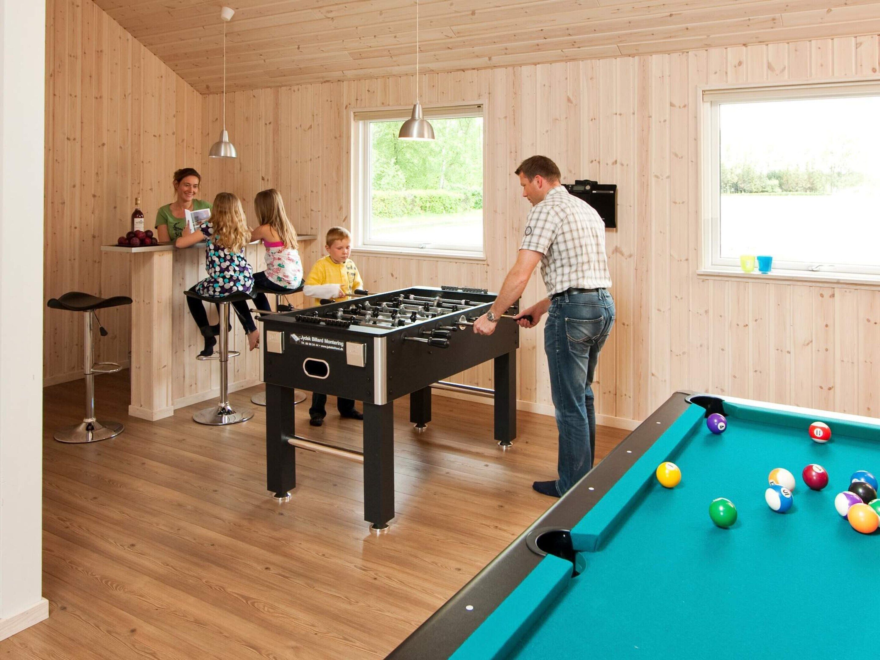 Ein Zimmer mit Kicker- und Billardtisch.