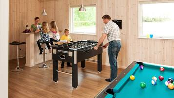 Ein Zimmer mit Kicker- und Billardtisch.