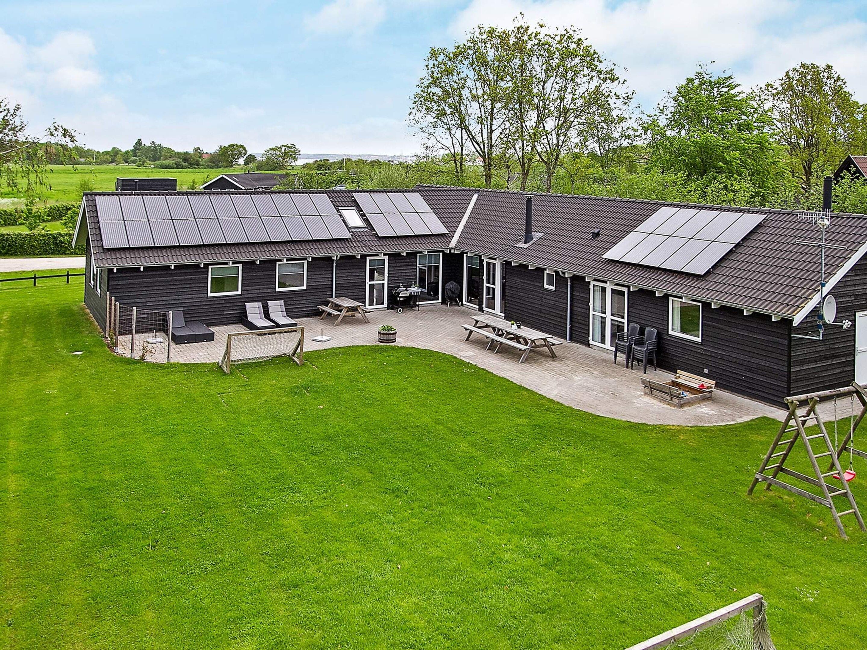 A modern building with a patio area, outdoor seating, and solar panels on the roof.