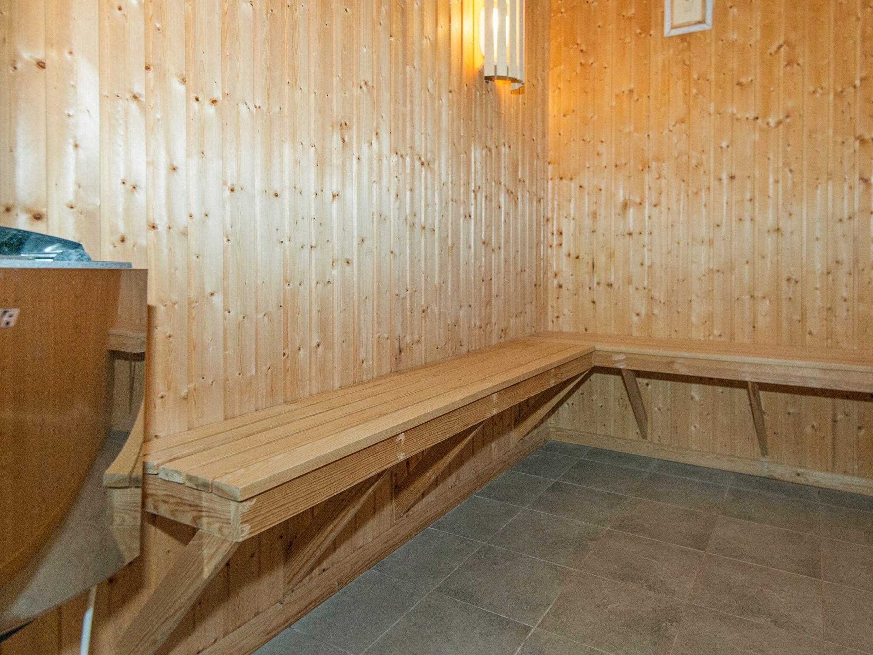Un vestíbulo de sauna con paredes y bancos de madera.