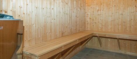 Un vestíbulo de sauna con paredes y bancos de madera.