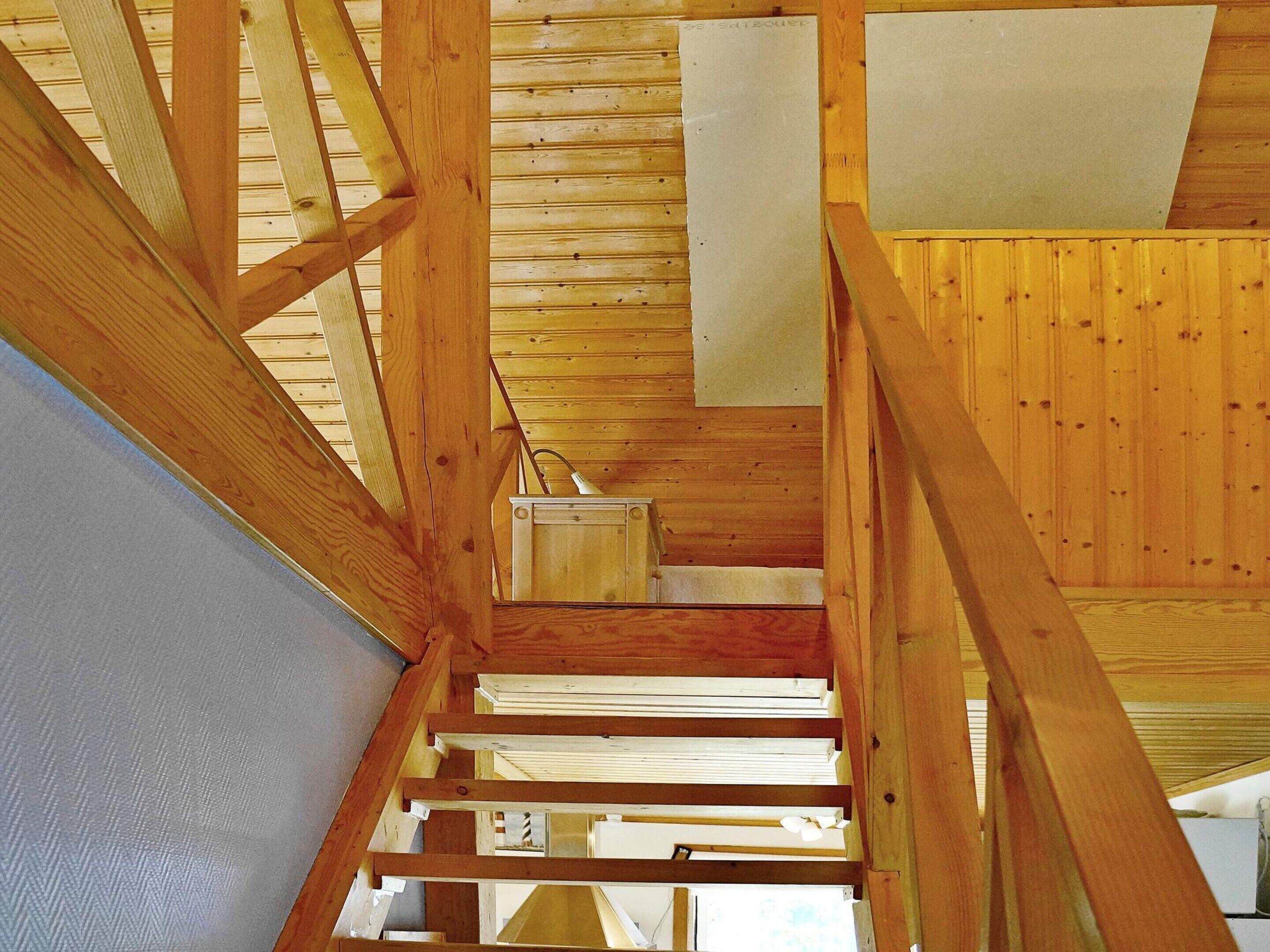 Un interior de madera con una escalera que sube a un nivel superior.