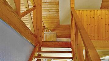 Un interior de madera con una escalera que sube a un nivel superior.