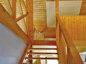 Un interior de fusta amb una escala que condueix a un nivell superior.