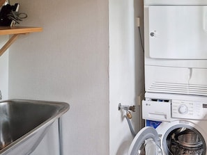 A laundry area with a washing machine, a sink, and a metal basin. - Holiday Home in SpekerÃ¶d (Spekeröd)