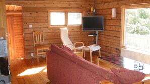 A cozy cabin interior with a sofa, two chairs, a table, a television, and a window. - Holiday Home in HÃ¤lleviksstrand (Hälleviksstrand)