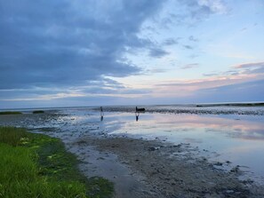 A beach with two people walking, calm water, and a cloudy sky. - Spacious Villa near Beach in Hadsund (Hadsund)