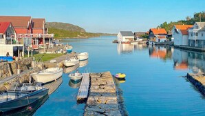 Un puerto con barcos amarrados, un muelle y edificios a lo largo del agua.