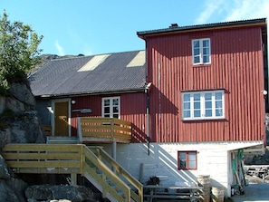 A red wooden building with a staircase leading to a wooden deck. - 6 Person Holiday Home in Ballstad-by Traum (Vestvågøy)