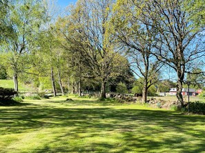 A grassy park with trees and a stone wall. - 4 Person Holiday Home in Klippan (Klippan)