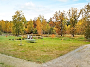 Un parc amb un petit cobert, un trampolí i un camí de terra.