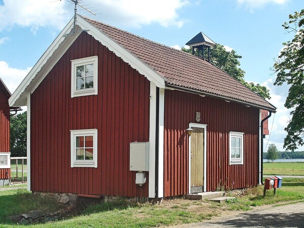 A red wooden building with a gabled roof, a small porch, and a single door. - 5 Person Holiday Home in Lonashult (Lönashult)