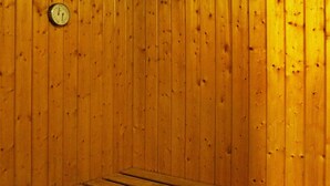 Un sauna avec des murs en bois et un banc.