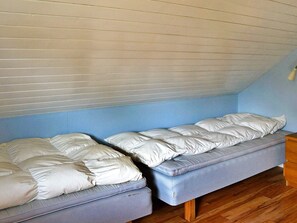 A room with two single beds, wooden flooring, and a sloped ceiling. - 5 Person Holiday Home in Lonashult (Lönashult)