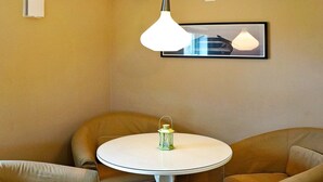 A room with a round table, two chairs, a hanging light fixture, and a framed picture on the wall. - 5 Person Holiday Home in Lonashult (Lönashult)