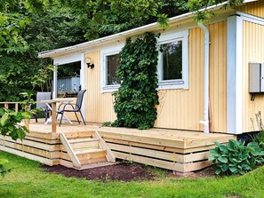 Een stacaravan met terras, tafel en stoelen.