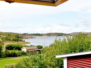 A coastal view with a house, greenery, and a body of water.