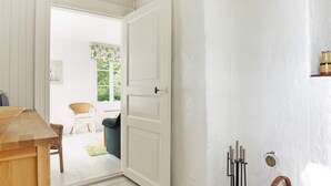 A room with a wooden table, a white door, and a wicker basket. - 5 Person Holiday Home in Mariefred (Mariefred)