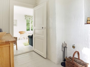A room with a wooden table, a white door, and a wicker basket. - 5 Person Holiday Home in Mariefred (Mariefred)