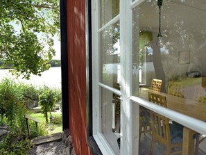 A room with a large window overlooking a garden and a body of water. - 5 Person Holiday Home in Mariefred (Mariefred)