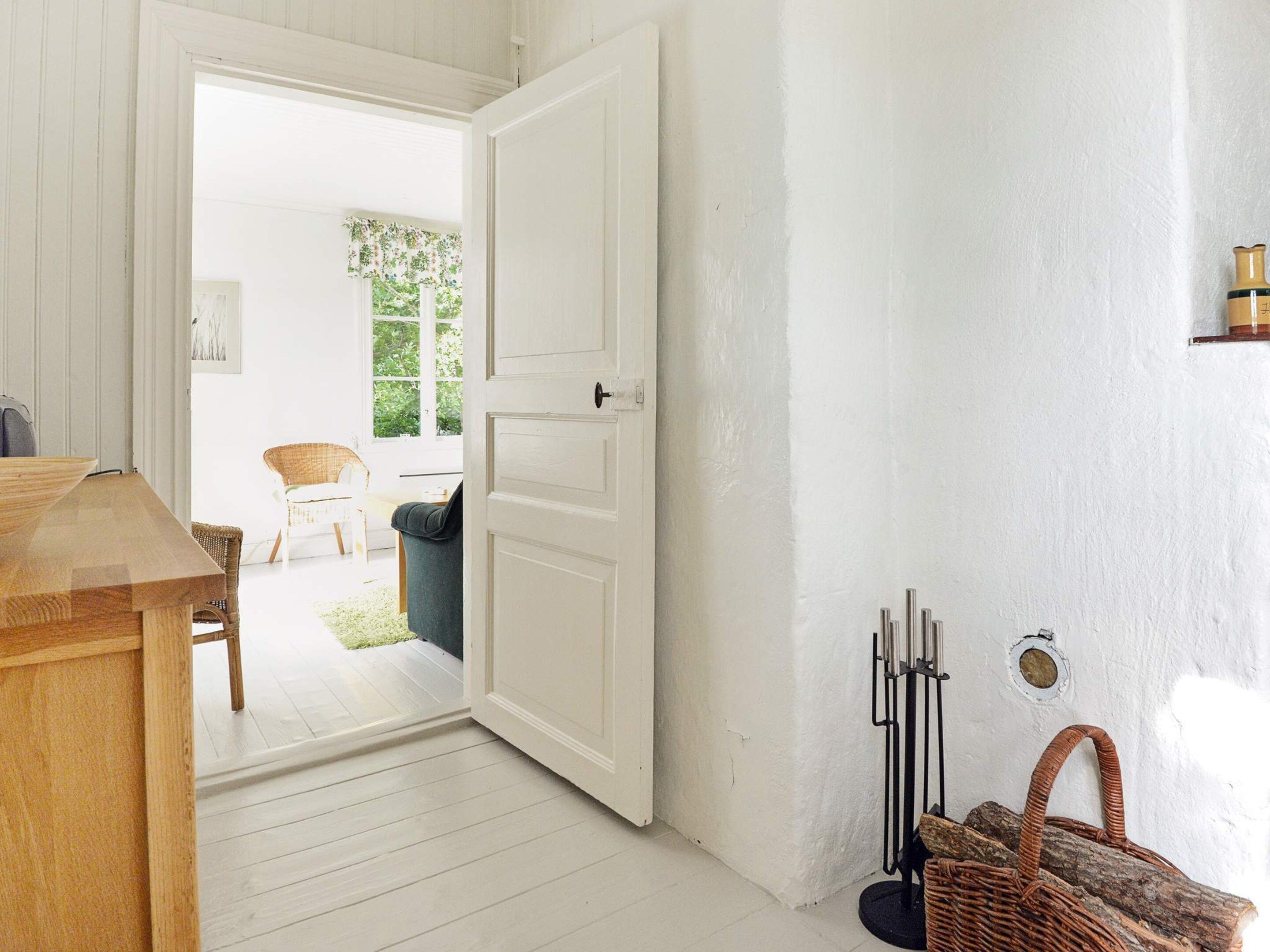 A room with a wooden table, a white door, and a wicker basket.
