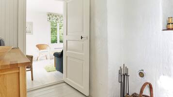 A room with a wooden table, a white door, and a wicker basket.