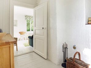 A room with a wooden table, a white door, and a wicker basket. - 5 Person Holiday Home in Mariefred (Mariefred)