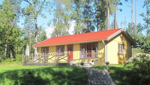 A yellow building with a red roof, a wooden fence, and a stone staircase leading to the entrance. - Holiday Home in HÃ¥cksvik (Håcksvik)