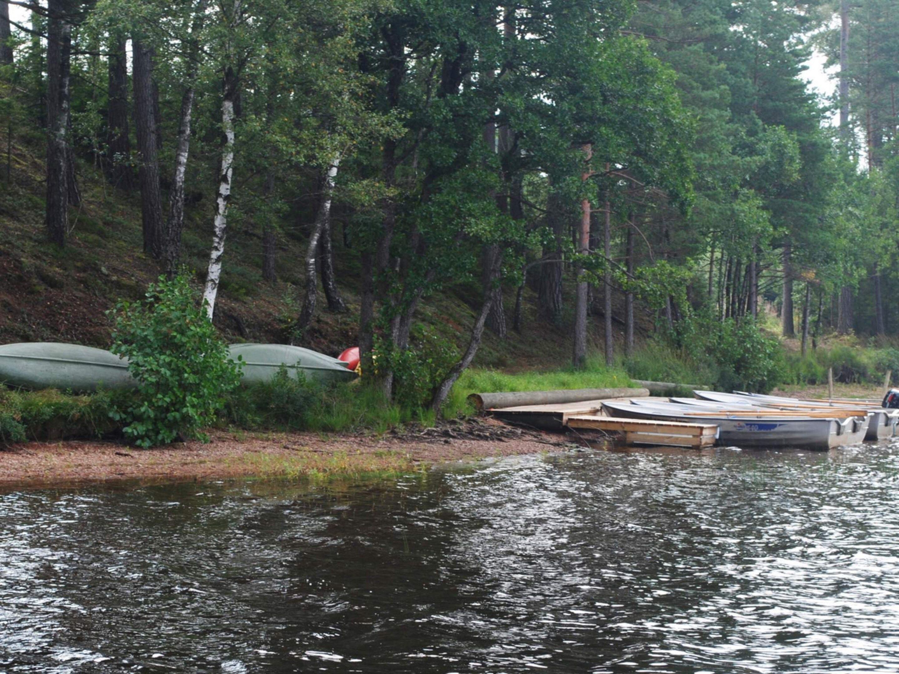 A riverside campsite with canoes and a dock.