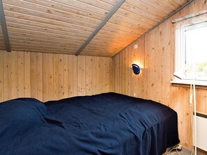 A single bed in a room with wooden walls and a sloped ceiling. - 4 Star Holiday Home in Stege (Stege)