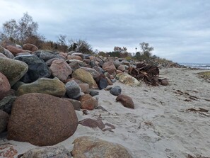 A beach with large rocks and sand. - 4 Star Holiday Home in Stege (Stege)