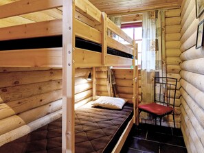A cabin with bunk beds, a small chair, and a window with curtains. - Holiday Home in SÃ¤len (Lima)