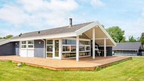 Una casa moderna con un porche cubierto, ventanas amplias y una terraza.