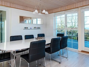 Una sala da pranzo moderna con un tavolo bianco, sedie nere e un centrotavola decorativo.